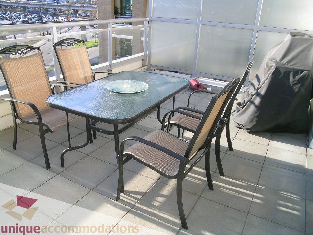 Furnished patio with glass table, chairs, and city view. - 305 - 1030 Quebec Street, Vancouver Downtown