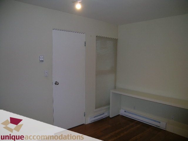 Bright bedroom with hardwood floors and a white door. - 2234 York Ave, Vancouver West Side