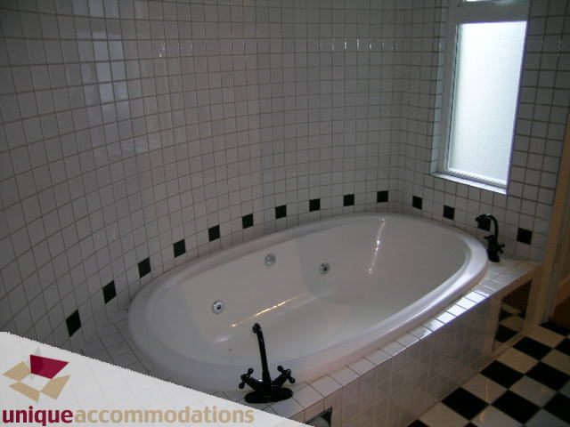 Bathroom with corner tub, white and black checkered tiles, frosted window. - 2234 York Ave, Vancouver West Side