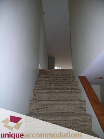 Furnished staircase with woven carpet and wooden handrail. - 2234 York Ave, Vancouver West Side