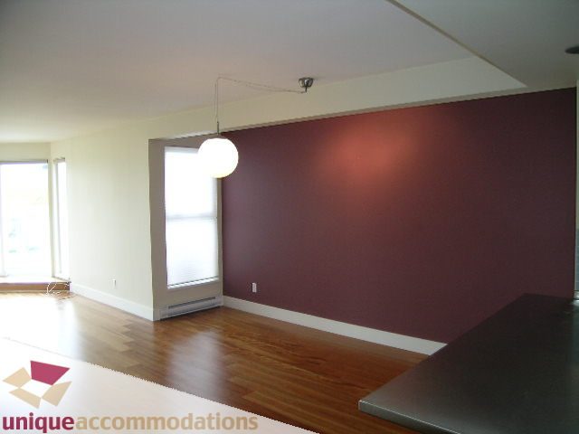 Open living space with hardwood floors, modern lighting, and a maroon accent wall. - 2234 York Ave, Vancouver West Side