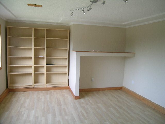 Spacious living room with built-in shelving and hardwood floors. - 660 Blueridge Ave, North Vancouver