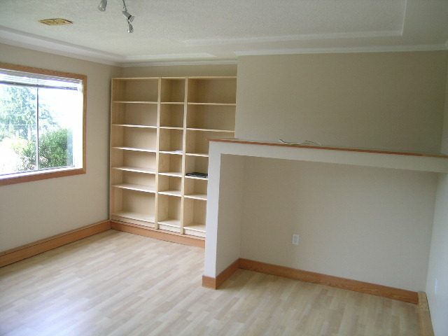 Spacious den with built-in shelving and hardwood floors, perfect for a cozy reading nook. - 660 Blueridge Ave, North Vancouver