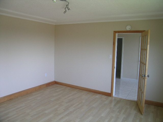 Spacious living room with hardwood floors and a sliding glass door leading to a balcony. - 660 Blueridge Ave, North Vancouver
