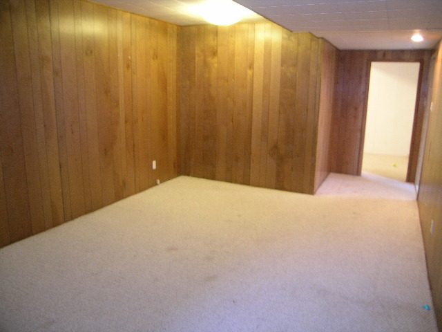 Spacious den with wood-paneled walls and carpeted floor, perfect for relaxation or work. - 660 Blueridge Ave, North Vancouver