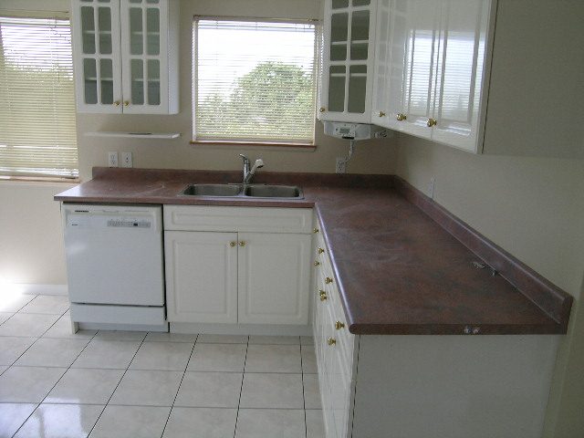 Bright kitchen with granite countertops, white cabinets, and a dishwasher. - 660 Blueridge Ave, North Vancouver