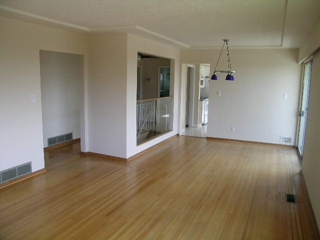 Spacious open-concept living room with hardwood floors and modern pendant lighting. - 660 Blueridge Ave, North Vancouver