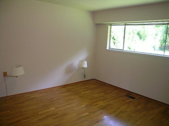 Spacious living room with hardwood floors and large windows. - 660 Blueridge Ave, North Vancouver