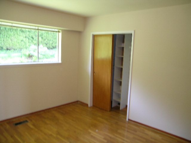 Spacious bedroom with hardwood floors and a closet leading to a second room. - 660 Blueridge Ave, North Vancouver