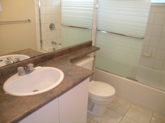 Bathroom with granite countertop and modern sink, featuring a bathtub and toilet. - 660 Blueridge Ave, North Vancouver