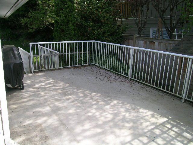 Spacious patio with white railing and outdoor grill, perfect for relaxing. - 660 Blueridge Ave, North Vancouver