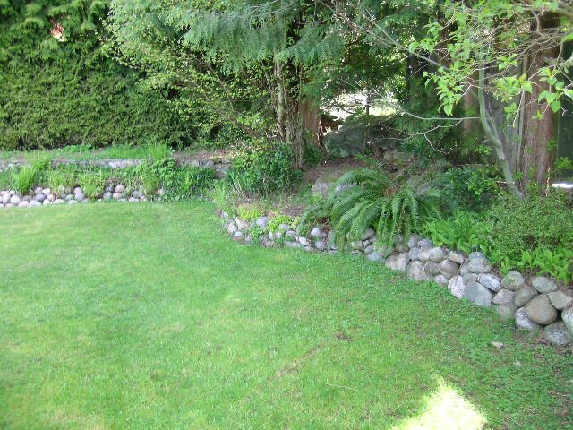 Lush garden with stone borders and vibrant greenery, perfect for relaxation. - 660 Blueridge Ave, North Vancouver