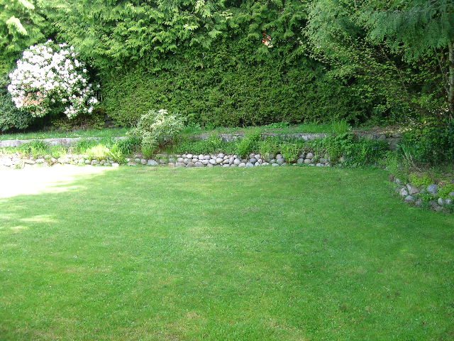Lush backyard with stone pathways and greenery, perfect for relaxation. - 660 Blueridge Ave, North Vancouver