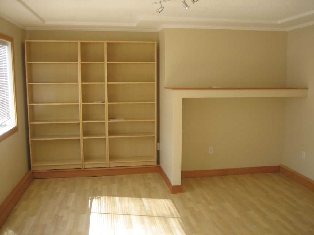 Spacious living room with built-in shelving and hardwood floors. - 660 Blueridge Ave, North Vancouver