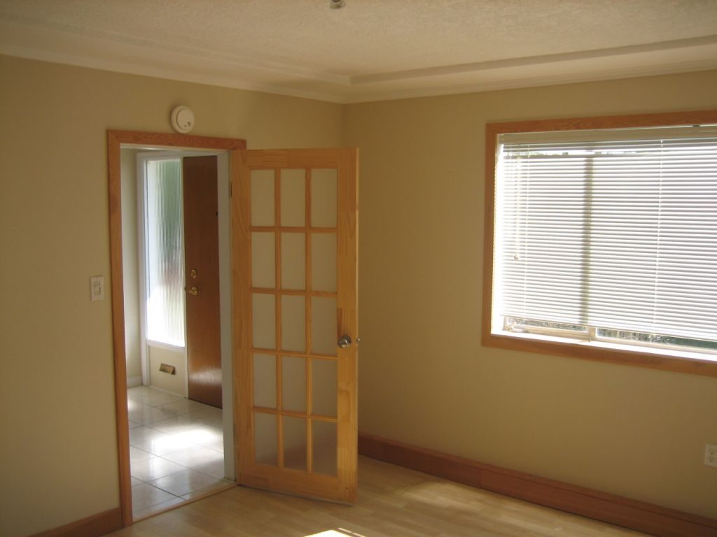 Spacious living room with hardwood floors and large windows, leading to a den. - 660 Blueridge Ave, North Vancouver