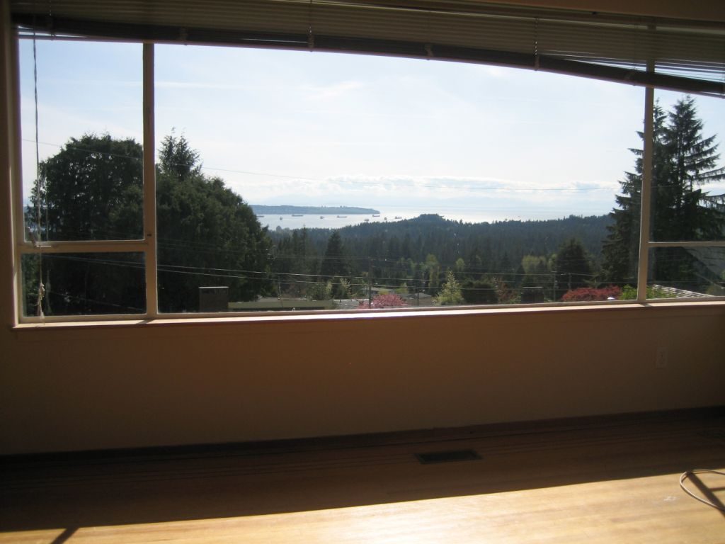 Spacious living room with hardwood floors and a stunning city view. - 660 Blueridge Ave, North Vancouver