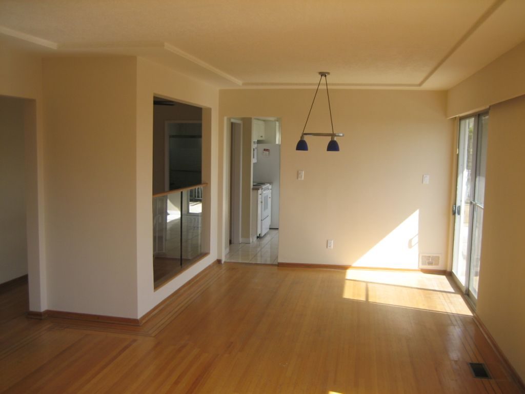 Spacious open-concept living room with hardwood floors and a modern chandelier. - 660 Blueridge Ave, North Vancouver