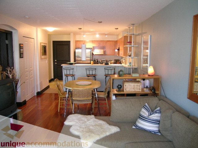 Open-concept living space with hardwood floors, modern furnishings, and a cozy corner. - 201-365 E 1st Ave, North Vancouver