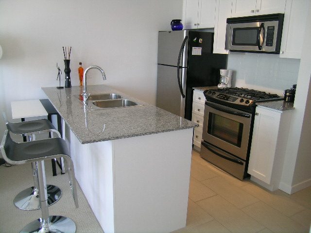 Bright kitchen with granite countertops, stainless steel appliances, and modern cabinetry. - 1703 - 480 Robson Street, Vancouver Downtown