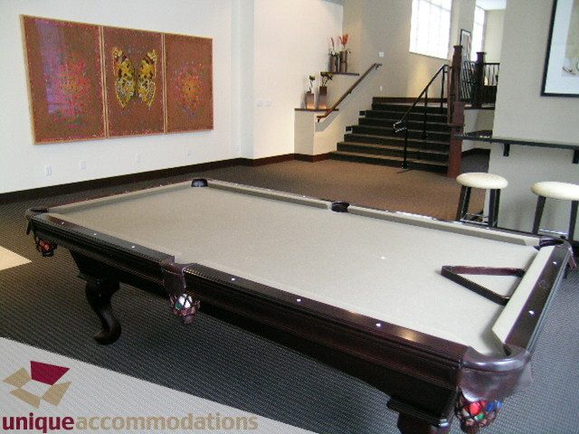 Furnished living room with a pool table, modern artwork, and a staircase leading to the upper level. - 2103 - 1001 Homer Street, Vancouver Downtown