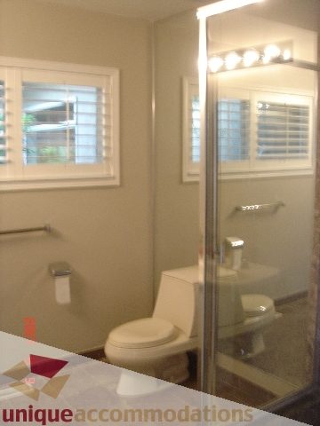 Furnished bathroom with a toilet, shower, and window view. - 100 Lions Bay Avenue, West Vancouver