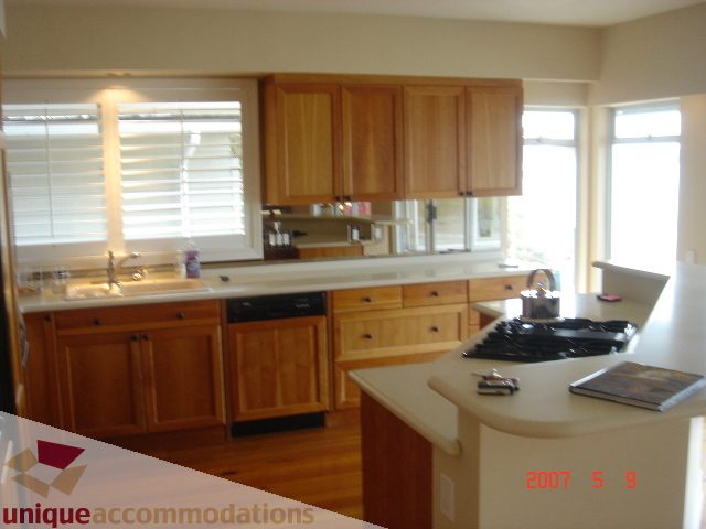 Bright kitchen with light wood cabinets, granite countertops, and hardwood floors. - 100 Lions Bay Avenue, West Vancouver
