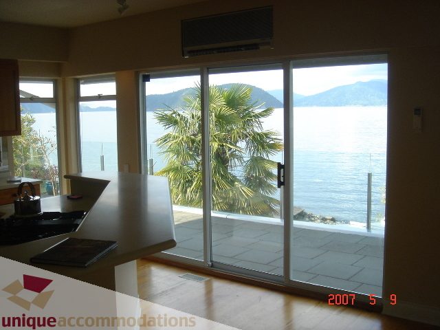 Bright kitchen with hardwood floors and a stunning city view, featuring large sliding glass doors leading to a patio.