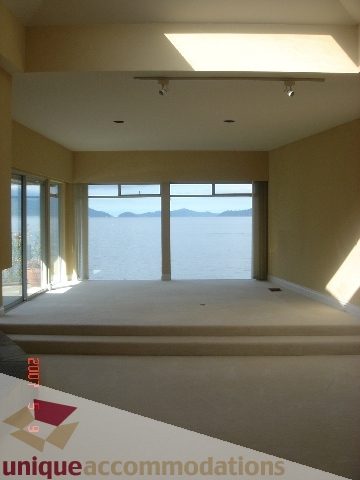 Spacious living room with large windows and a stunning ocean view. - 100 Lions Bay Avenue, West Vancouver