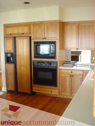 Bright kitchen with wooden cabinets, countertop, and hardwood floors. - 100 Lions Bay Avenue, West Vancouver