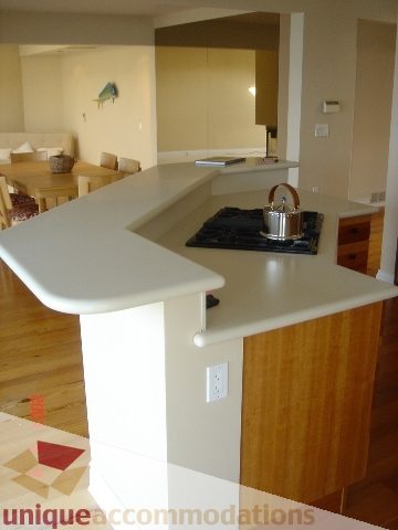 Bright kitchen with white countertops, wooden island, and hardwood floors. - 100 Lions Bay Avenue, West Vancouver
