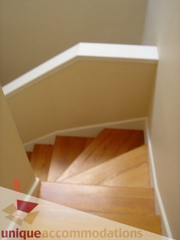 Staircase leading to upper floor with wooden steps and white trim. - 100 Lions Bay Avenue, West Vancouver