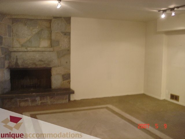 Spacious living room with stone fireplace and modern lighting. - 100 Lions Bay Avenue, West Vancouver