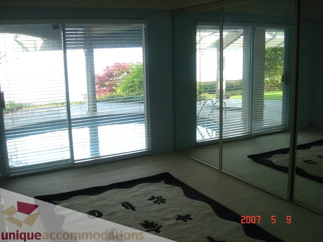 Furnished living room with large windows, view of trees and street, modern decor. - 100 Lions Bay Avenue, West Vancouver