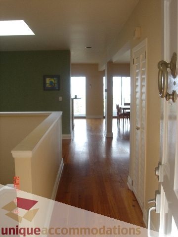 Bright hallway with hardwood floors and white trim, leading to a dining area. - 100 Lions Bay Avenue, West Vancouver