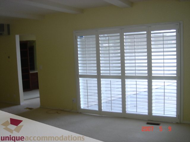 Bright living room with large sliding glass doors and white plantation shutters. - 100 Lions Bay Avenue, West Vancouver