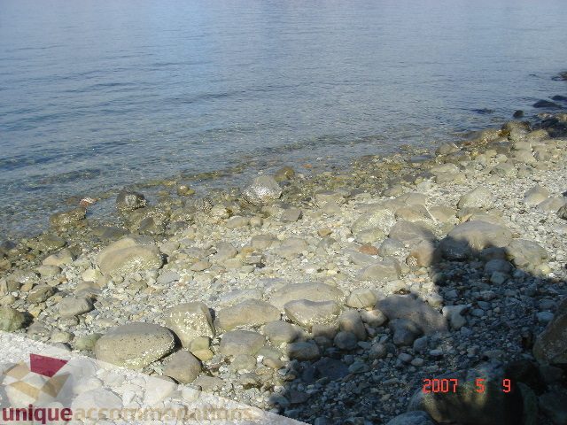 Beachfront house with pebbled shoreline and calm water view. - 100 Lions Bay Avenue, West Vancouver