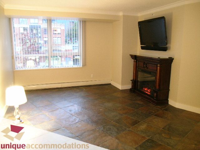 Bright living room with tiled floor, fireplace, and city view. - 2C - 199 Drake Street, Vancouver Downtown