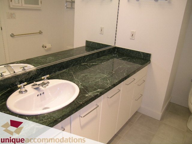 Bathroom with dark green marble countertops and white cabinets. - 2C - 199 Drake Street, Vancouver Downtown