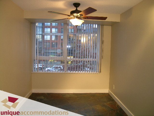 Bright living room with large windows, city view, and ceiling fan. - 2C - 199 Drake Street, Vancouver Downtown