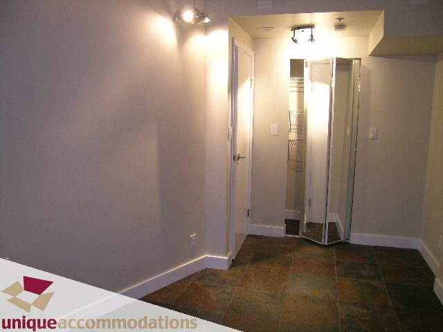 Bright hallway leading to a well-lit kitchen with granite countertops and tiled flooring. - 2C - 199 Drake Street, Vancouver Downtown
