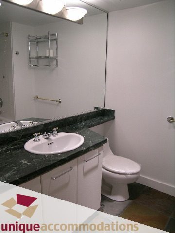 Bright bathroom with dark green marble countertops and white fixtures. - 2C - 199 Drake Street, Vancouver Downtown