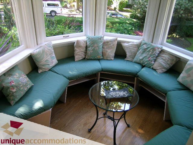 Bright sunroom with teal cushions, floral pillows, and hardwood floors. - 4177 West 15th Avenue, Vancouver West Side