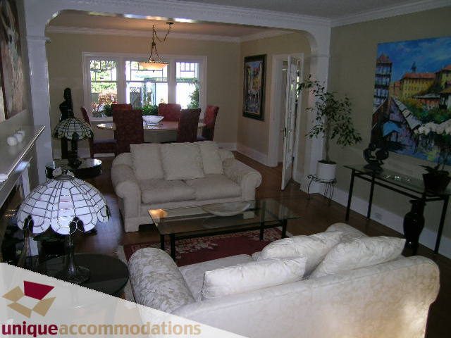 Spacious living room with white furniture, hardwood floors, and large windows. - 4177 West 15th Avenue, Vancouver West Side