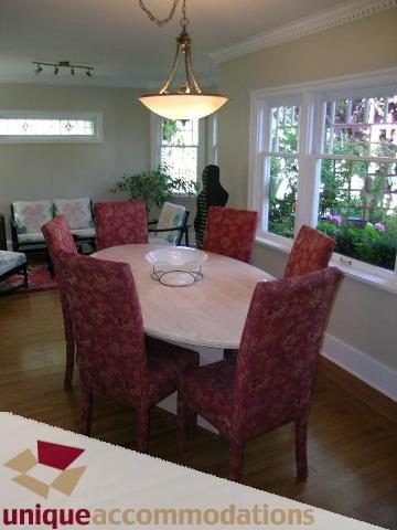 Furnished dining room with patterned chairs and large windows, hardwood floors. - 4177 West 15th Avenue, Vancouver West Side