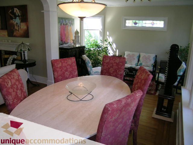 Furnished dining area with pink floral chairs and wooden table, natural light from window. - 4177 West 15th Avenue, Vancouver West Side