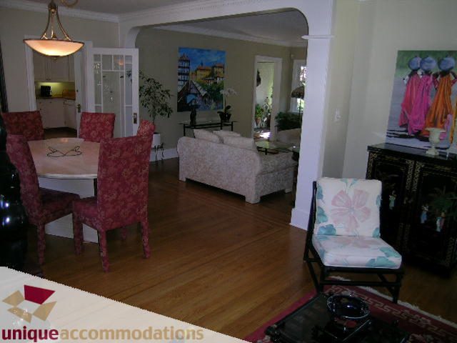 Furnished living room with hardwood floors, cozy seating, and artwork. - 4177 West 15th Avenue, Vancouver West Side