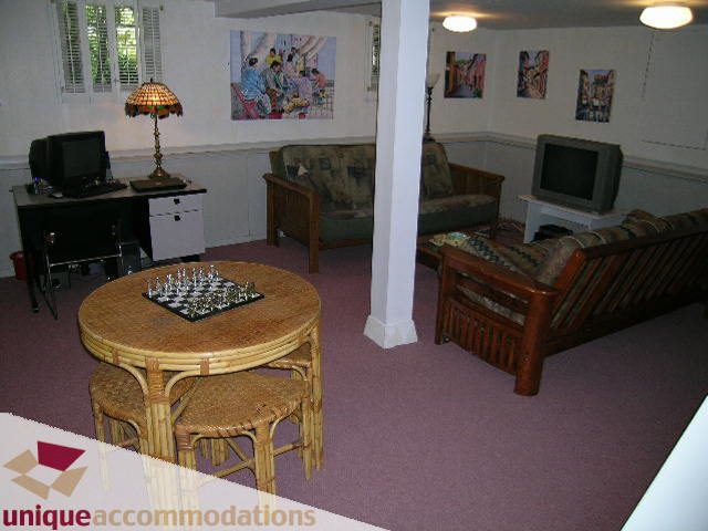 Furnished living room with round table, chess set, and wooden furniture. - 4177 West 15th Avenue, Vancouver West Side