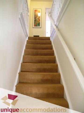 Staircase leading to upper floors with carpeted steps and white walls. - 4177 West 15th Avenue, Vancouver West Side