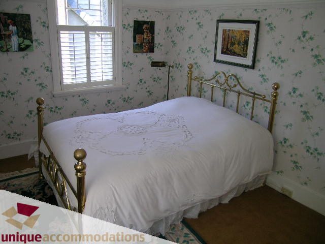 Bright bedroom with twin beds, floral wallpaper, and brass headboards. - 4177 West 15th Avenue, Vancouver West Side