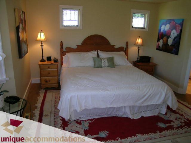 Spacious bedroom with twin beds, wooden headboard, and decorative pillows. - 4177 West 15th Avenue, Vancouver West Side